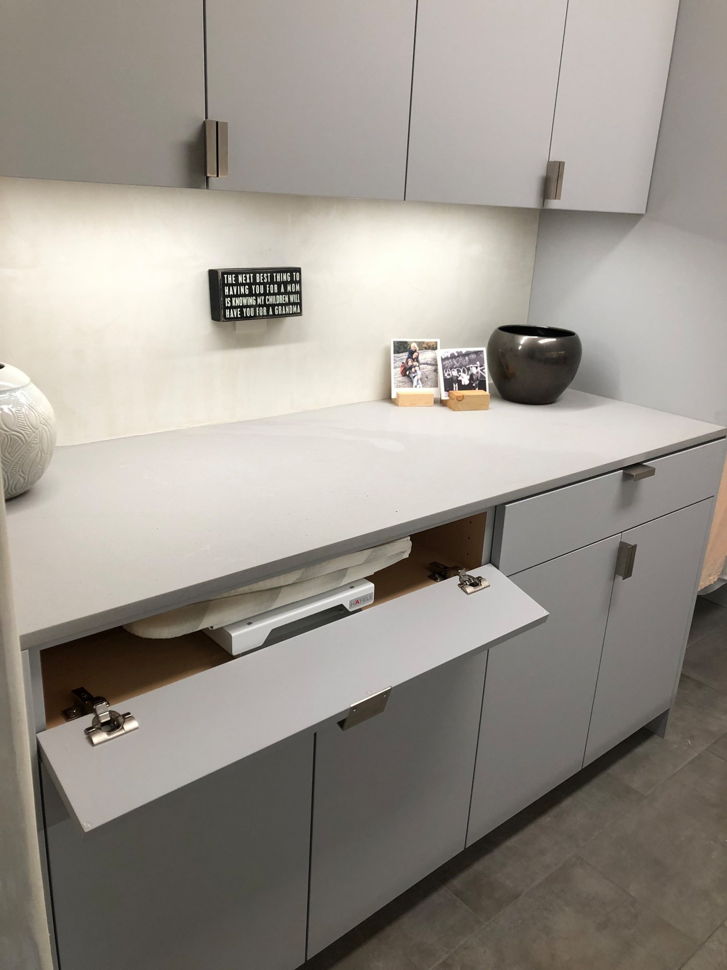 Mid-sized trendy galley gray floor dedicated laundry room with an undermount sink, flat-panel cabinets, gray cabinets, beige walls, a side-by-side washer/dryer and gray countertops, by Jensen Design in Telluride, CO