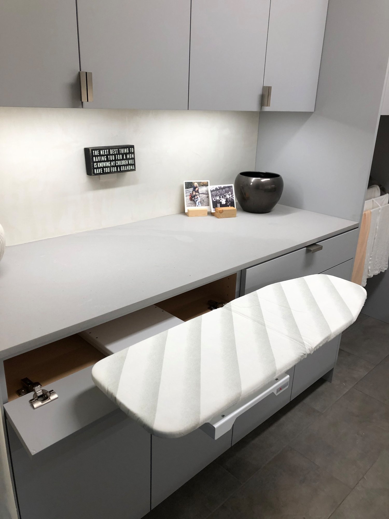Mid-sized contemporary galley gray floor dedicated laundry room with an undermount sink, flat-panel cabinets, gray cabinets, beige walls, a side-by-side washer/dryer and gray countertops, by Jensen Design in Telluride, CO