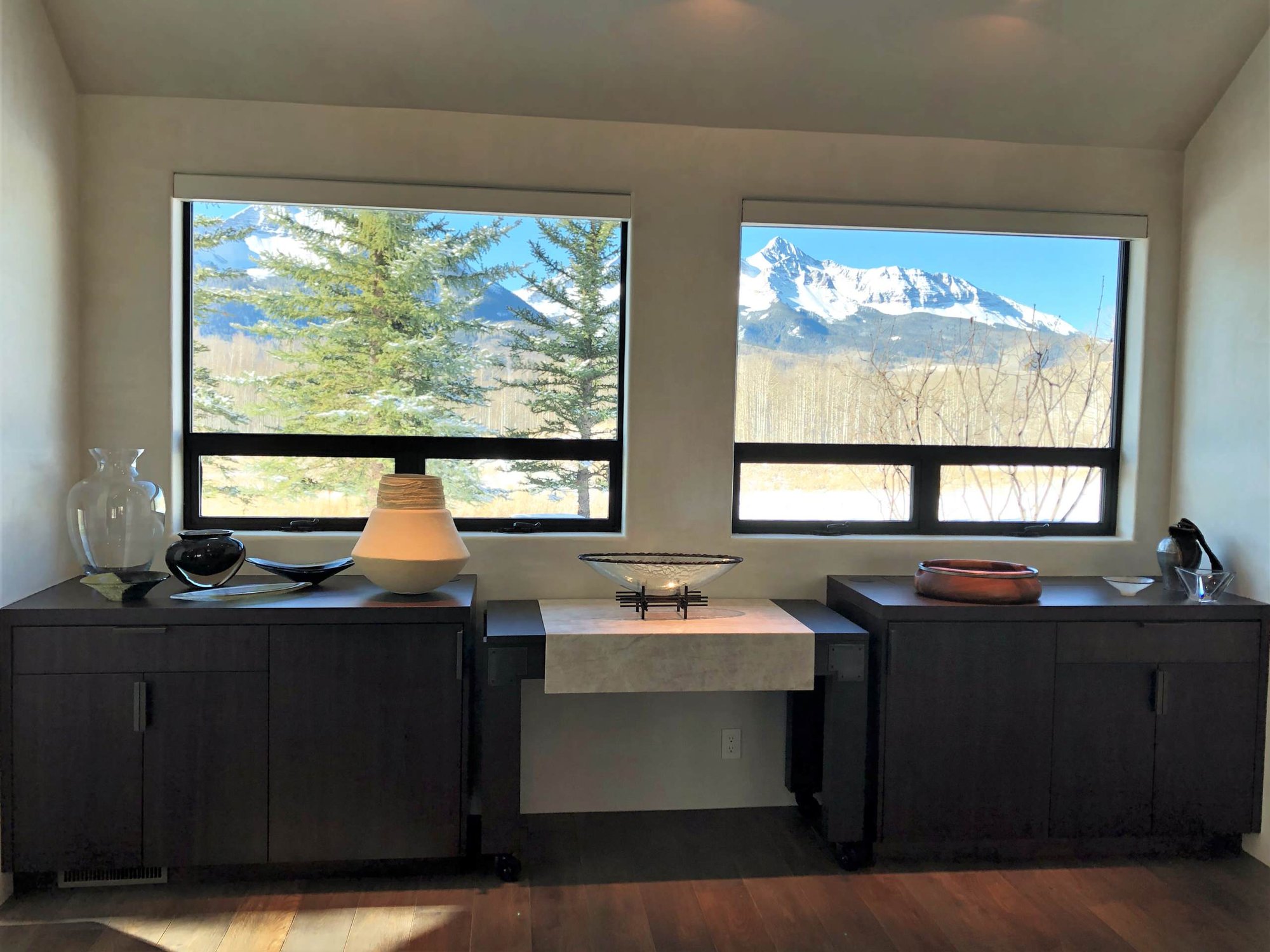 Large trendy galley medium tone wood floor, brown floor and vaulted ceiling open concept kitchen with an undermount sink, flat-panel cabinets, dark wood cabinets, colored appliances, an island and multicolored countertops, by Jensen Design in Telluride, CO