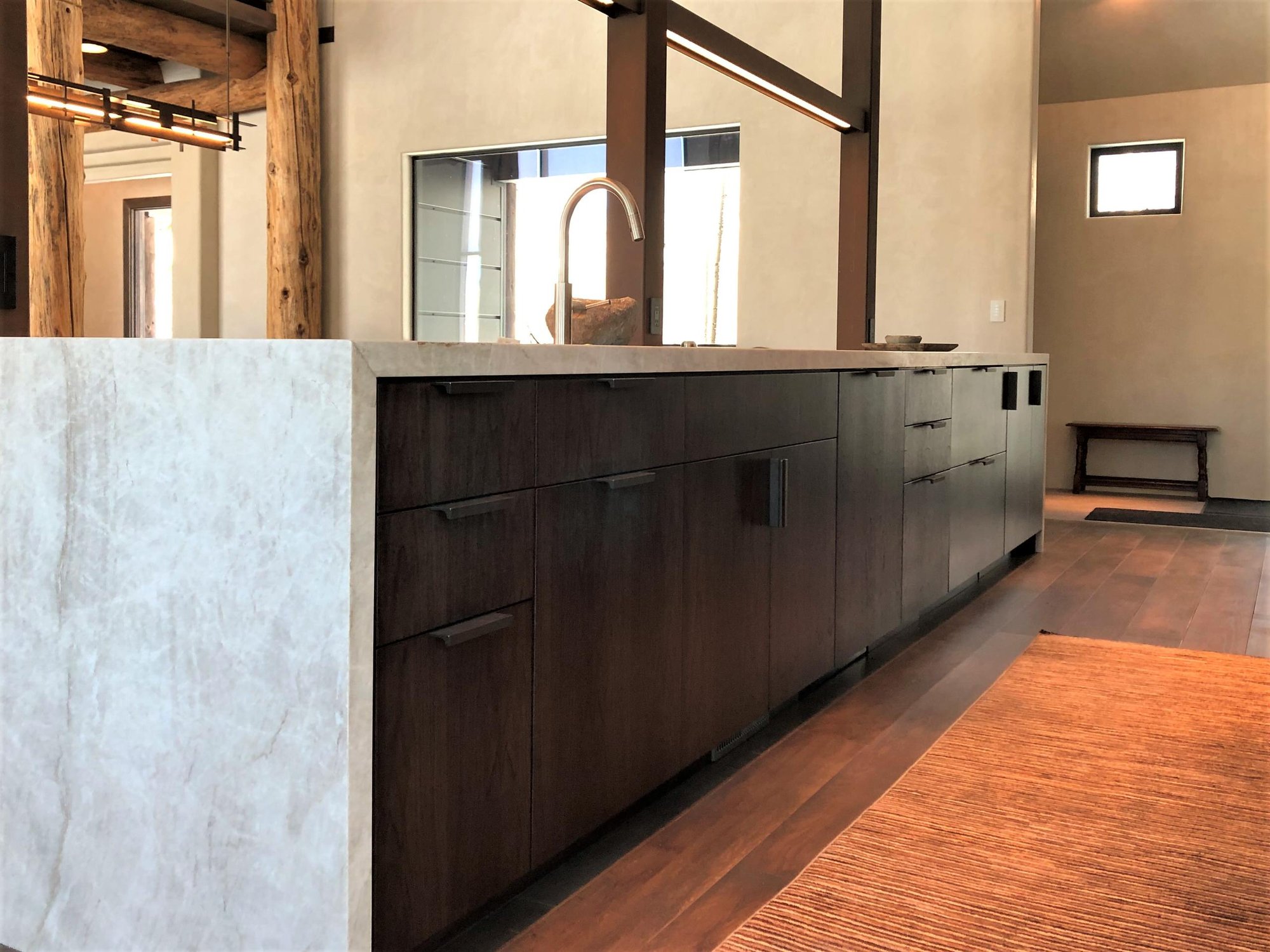 Large trendy galley medium tone wood floor, brown floor and vaulted ceiling open concept kitchen with an undermount sink, flat-panel cabinets, dark wood cabinets, colored appliances, an island and multicolored countertops, by Jensen Design in Telluride, CO
