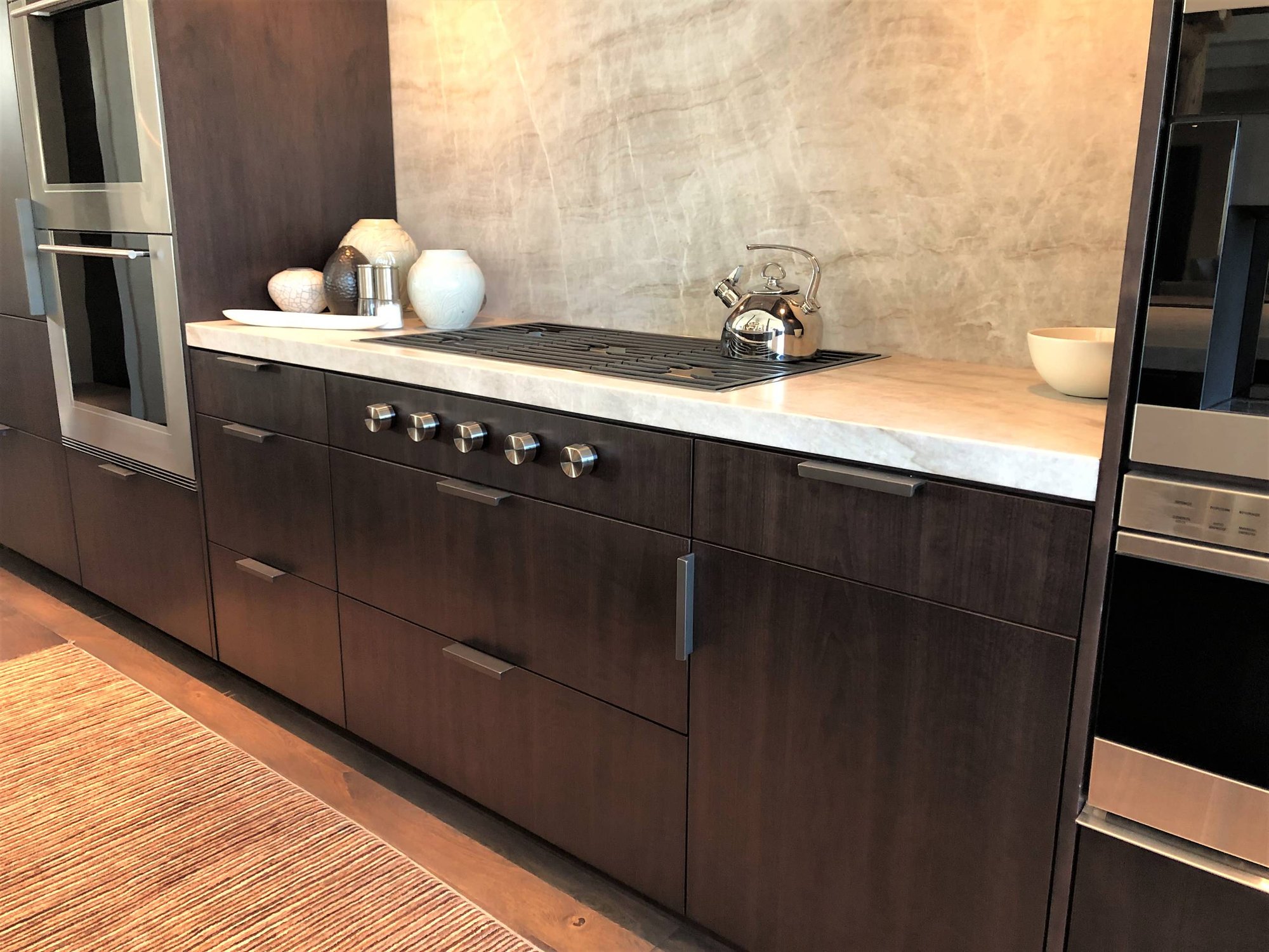 Large trendy galley medium tone wood floor, brown floor and vaulted ceiling open concept kitchen with an undermount sink, flat-panel cabinets, dark wood cabinets, colored appliances, an island and multicolored countertops, by Jensen Design in Telluride, CO