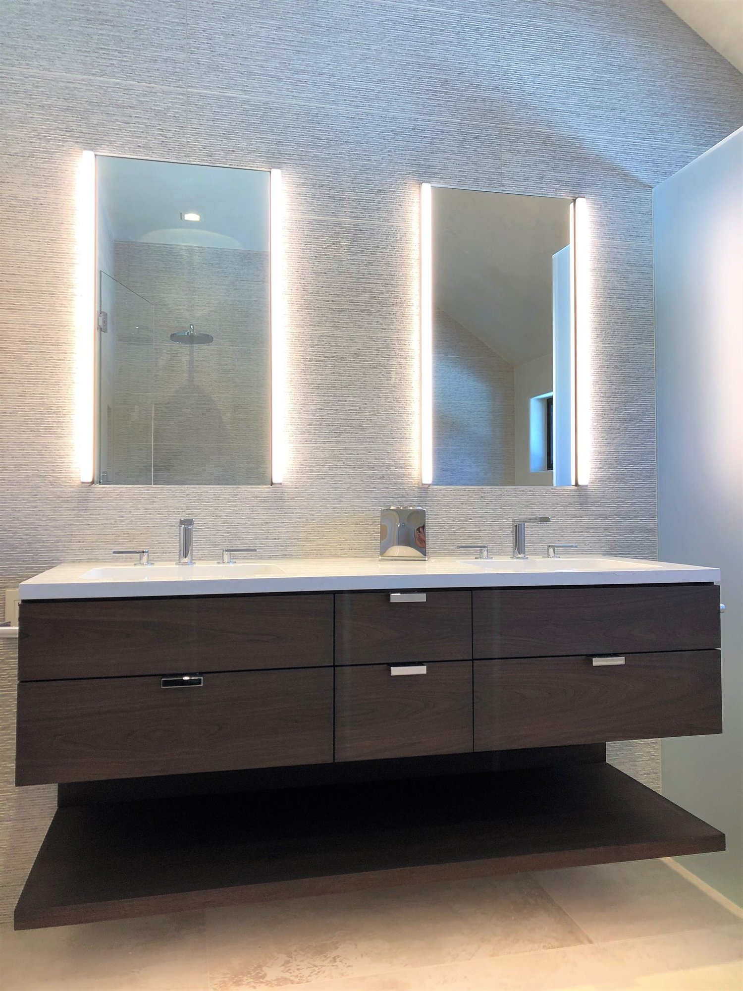 Mid-sized trendy master gray tile beige floor, double-sink and vaulted ceiling bathroom with flat-panel cabinets, dark wood cabinets, gray walls, an undermount sink, white countertops and a floating vanity, by Jensen Design in Telluride, CO
