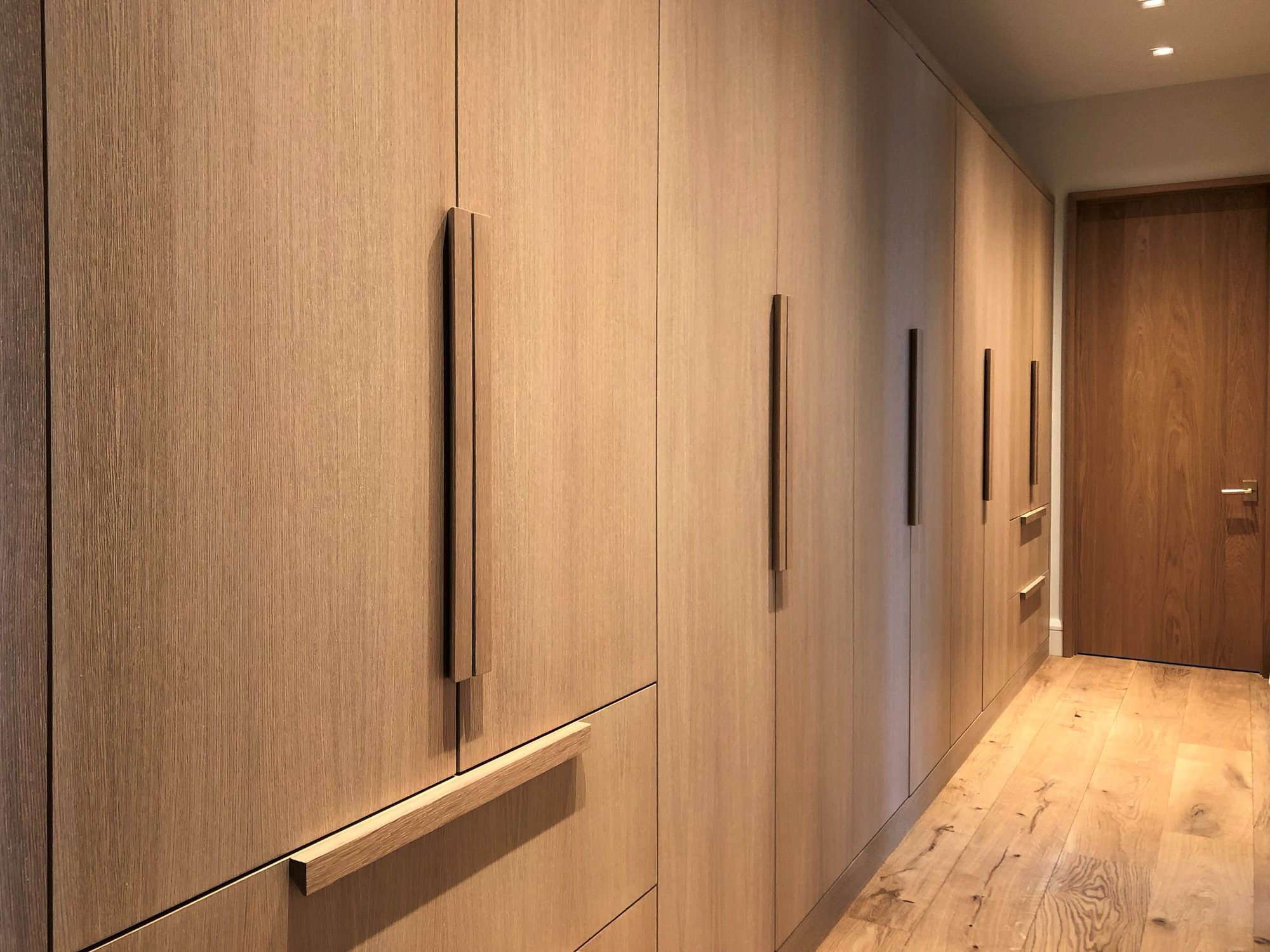 Large trendy light wood floor and brown floor hallway with brown walls, by Jensen Design in Telluride, CO