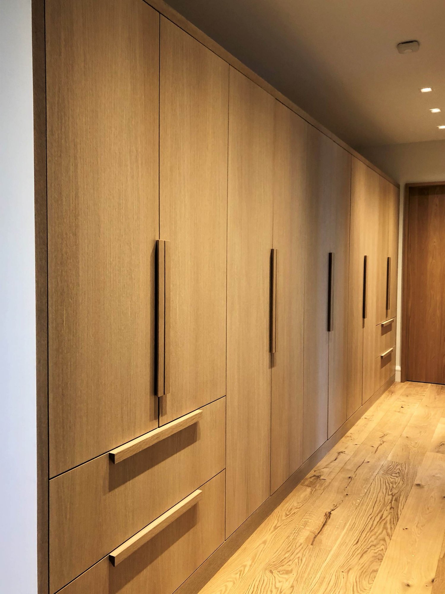 Large trendy light wood floor and brown floor hallway with brown walls, by Jensen Design in Telluride, CO