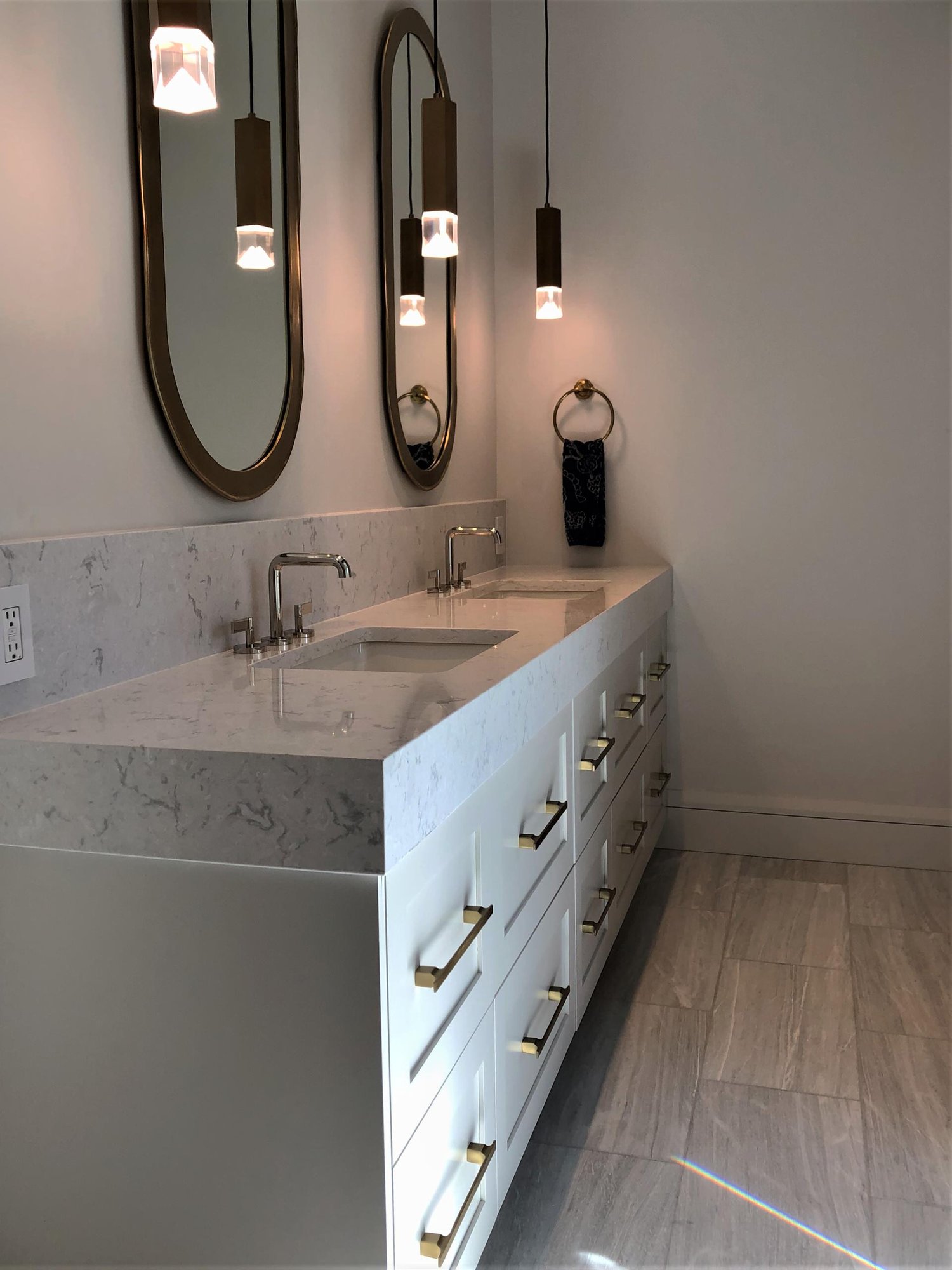 Mid-sized trendy master gray floor and double-sink toilet room with shaker cabinets, white cabinets, white walls, an undermount sink, white countertops and a built-in vanity, by Jensen Design in Telluride, CO