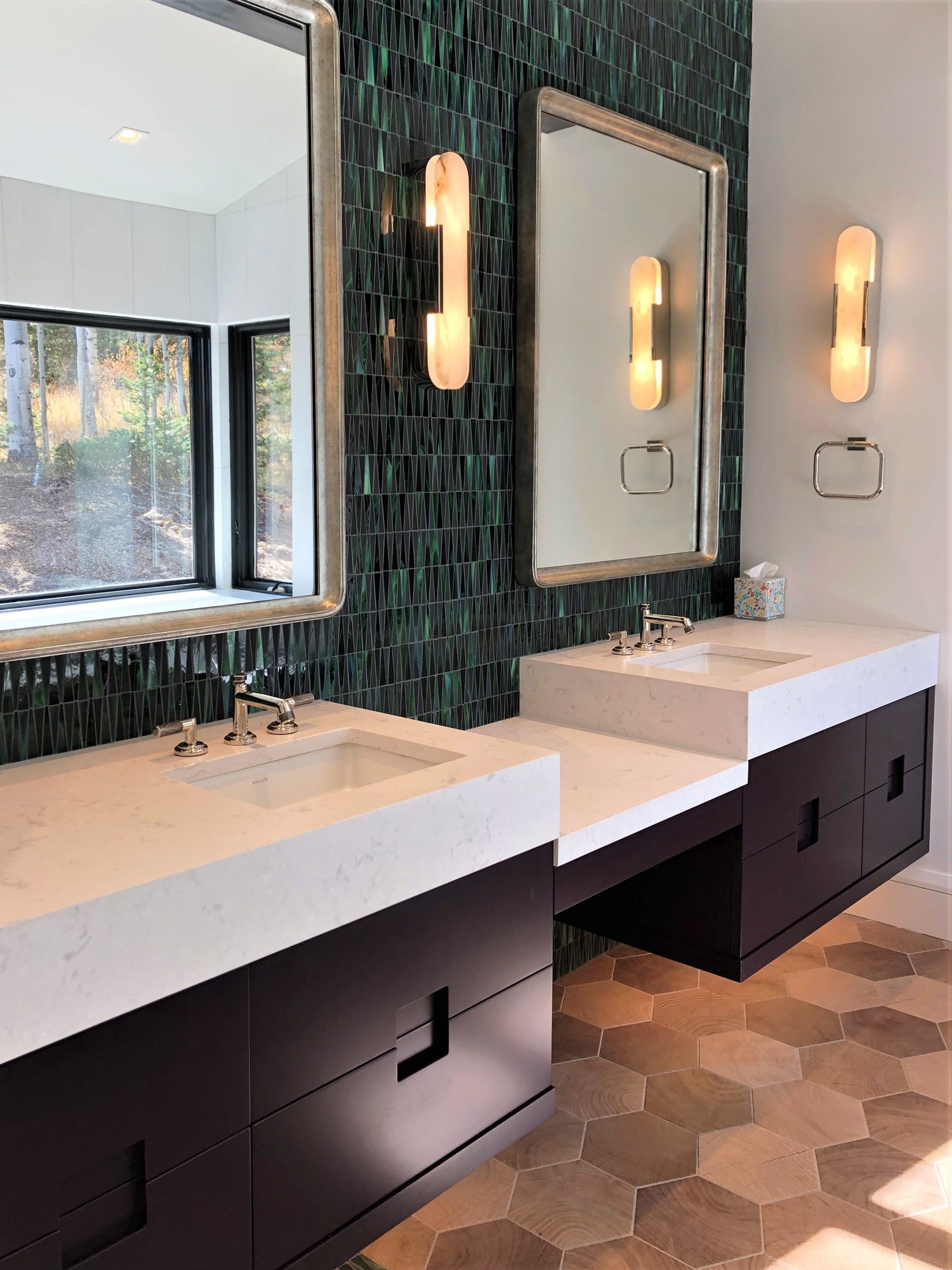 Mid-sized trendy master green tile and glass tile wood-look tile floor, brown floor, double-sink and vaulted ceiling bathroom with flat-panel cabinets, black cabinets, white walls, an undermount sink, a hinged shower door, white countertops and a floating vanity, by Jensen Design in Telluride, CO