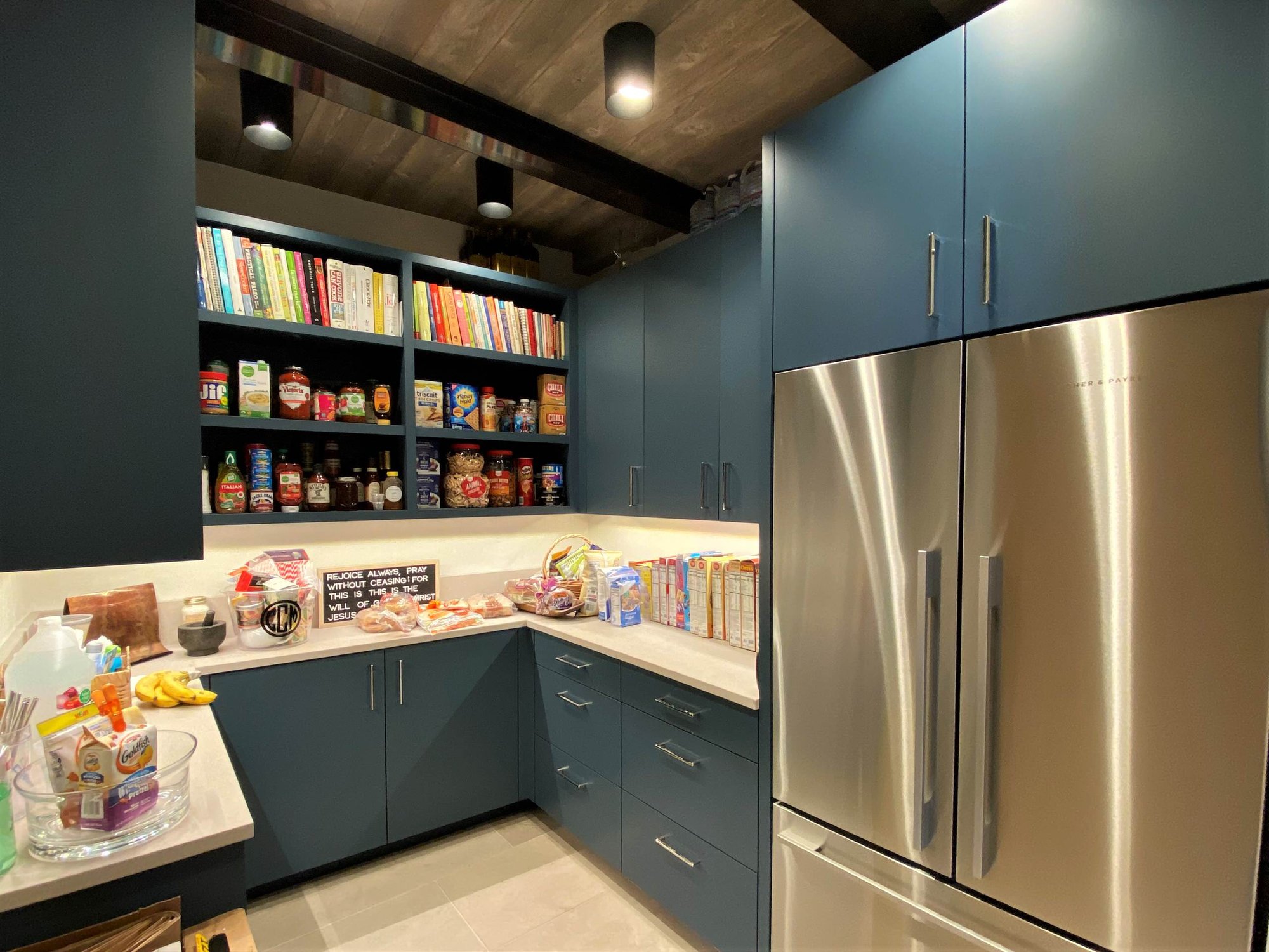 Large contemporary u-shaped limestone floor, gray floor and wood ceiling open concept kitchen with a farmhouse sink, flat-panel cabinets, blue cabinets, marble countertops, white backsplash, marble backsplash, paneled appliances, an island and white countertops, by Jensen Design in Telluride, CO