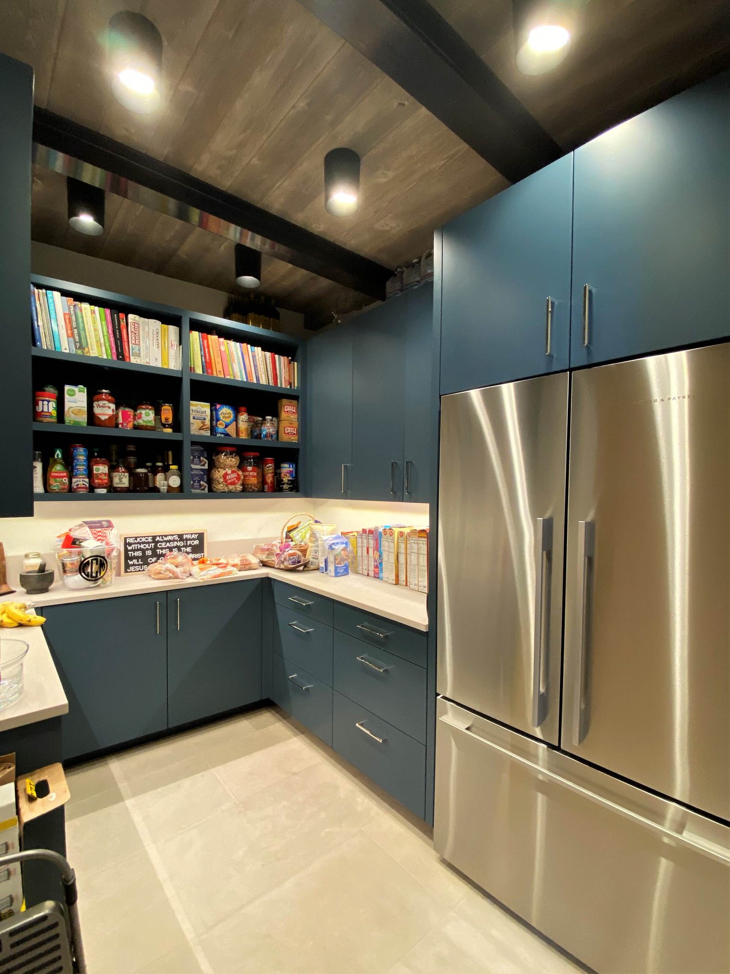 Large contemporary u-shaped limestone floor, gray floor and wood ceiling open concept kitchen with a farmhouse sink, flat-panel cabinets, blue cabinets, marble countertops, white backsplash, marble backsplash, paneled appliances, an island and white countertops, by Jensen Design in Telluride, CO
