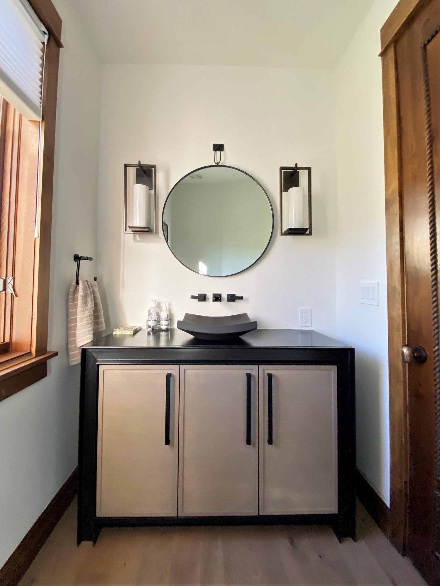 Small transitional 3/4 single-sink bathroom with recessed-panel cabinets, medium tone wood cabinets, black countertops and a freestanding vanity, by Jensen Design in Telluride, CO