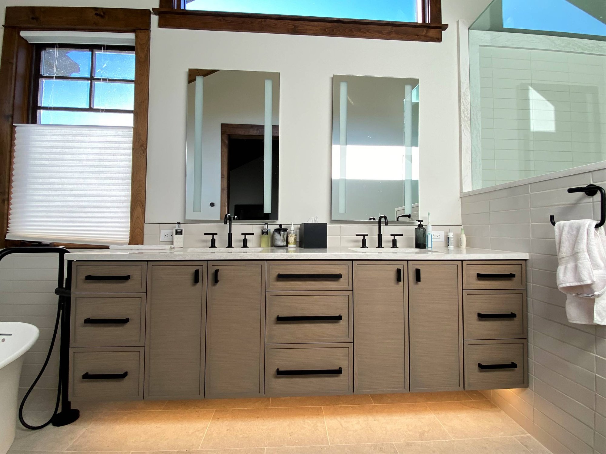 Mid-sized transitional master white tile double-sink bathroom with recessed-panel cabinets, medium tone wood cabinets, white walls, an undermount sink, white countertops and a floating vanity, by Jensen Design in Telluride, CO
