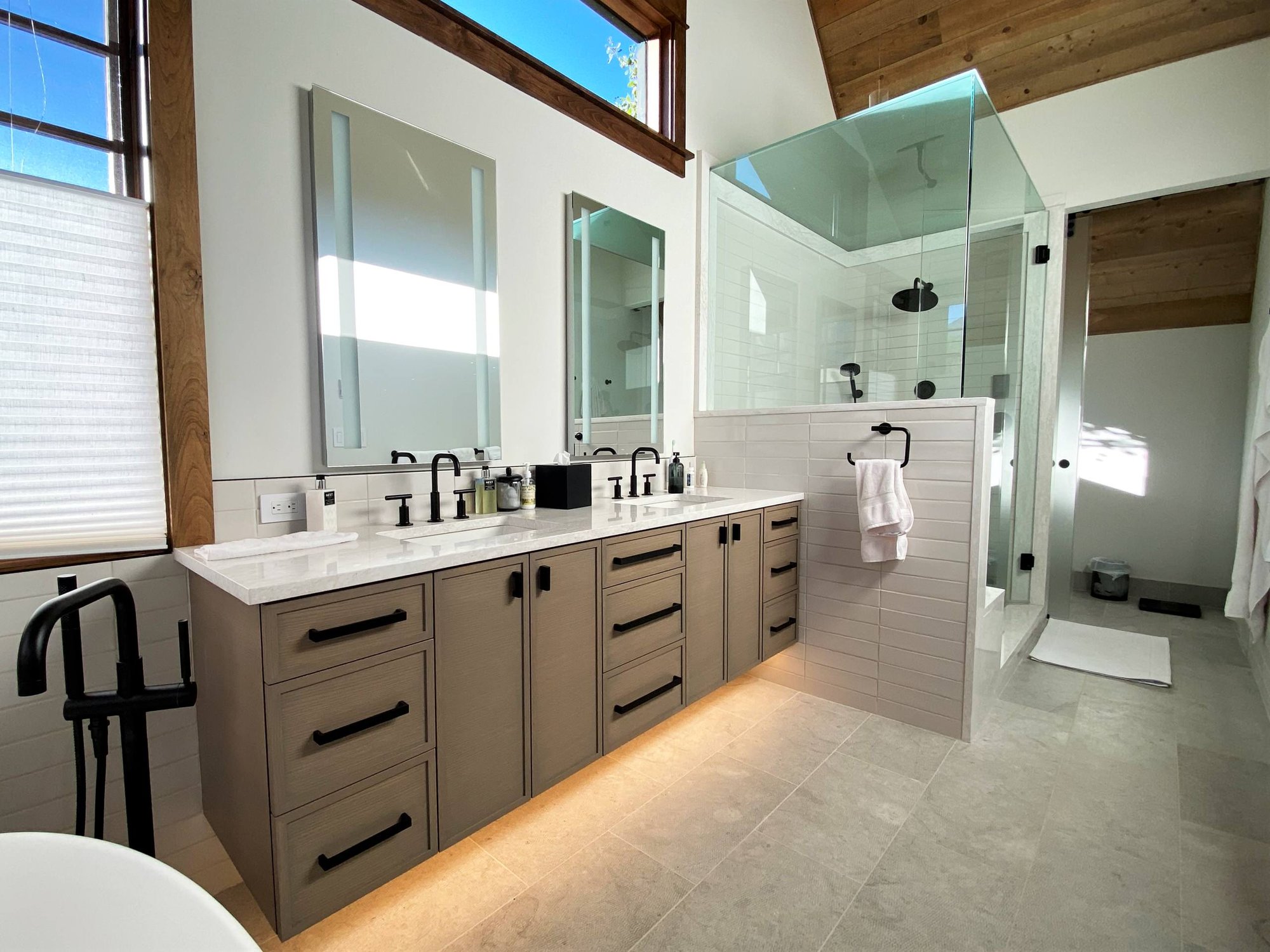 Mid-sized transitional master white tile double-sink bathroom with recessed-panel cabinets, medium tone wood cabinets, white walls, an undermount sink, white countertops and a floating vanity, by Jensen Design in Telluride, CO