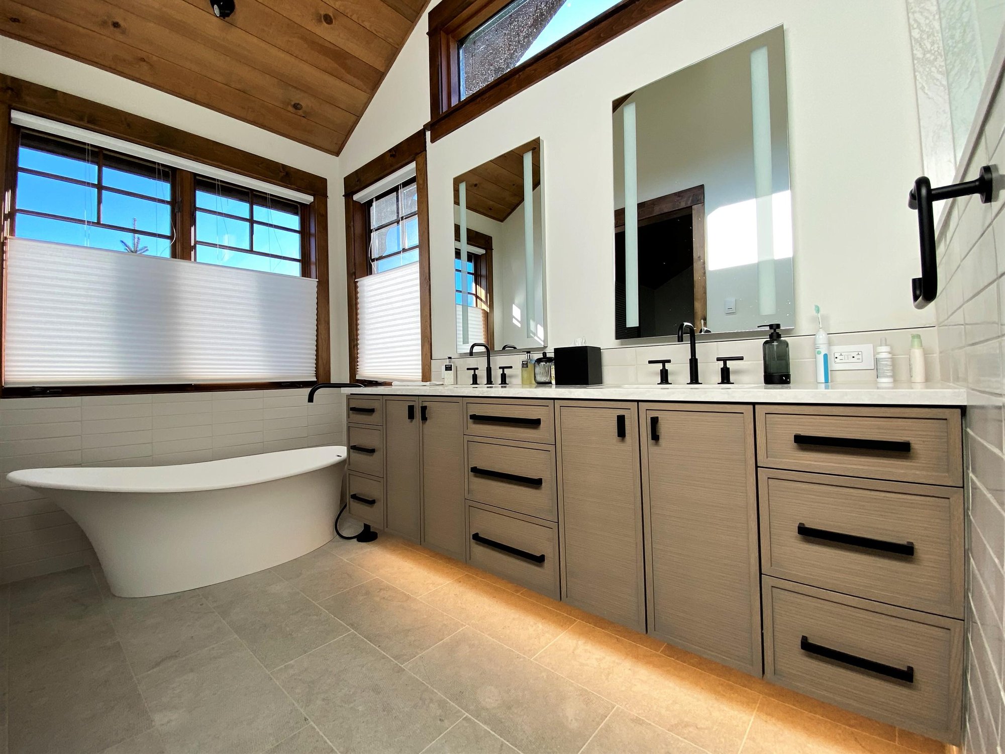 Mid-sized transitional master white tile double-sink bathroom with recessed-panel cabinets, medium tone wood cabinets, white walls, an undermount sink, white countertops and a floating vanity, by Jensen Design in Telluride, CO