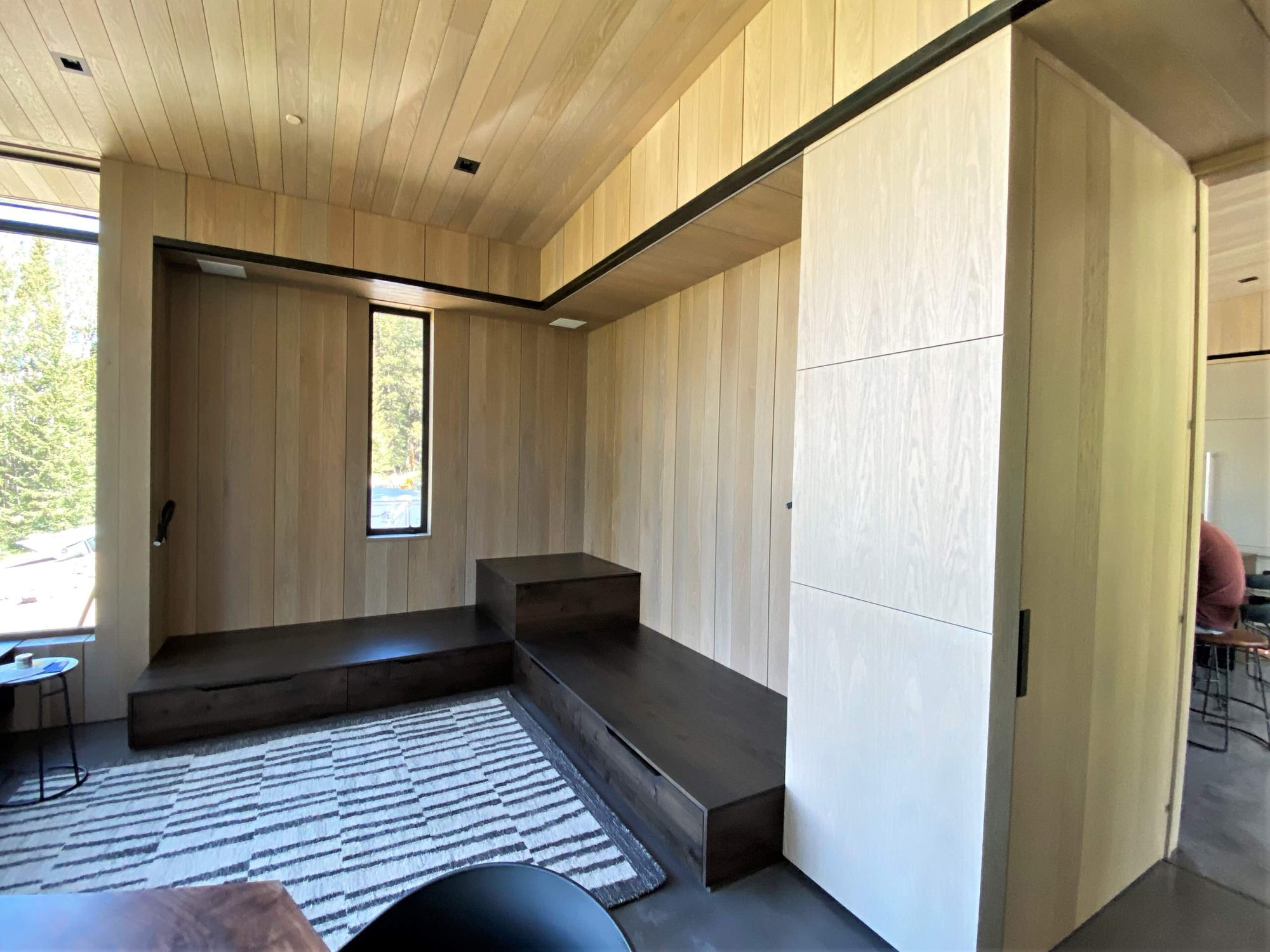 Mid-sized trendy enclosed concrete floor, gray floor, wood ceiling and wood wall family room, by Jensen Design in Telluride, CO