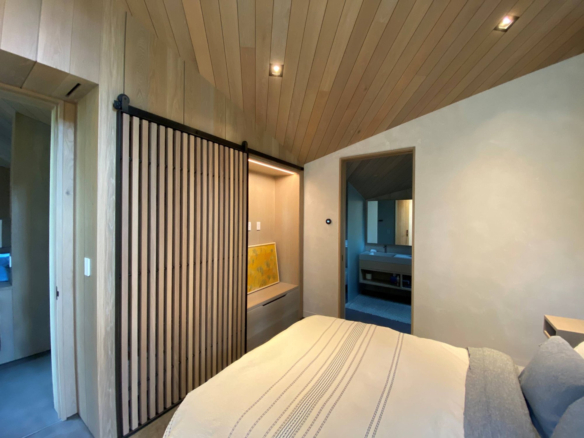 Mid-sized trendy guest concrete floor, gray floor, wood ceiling and wood wall bedroom with beige walls, by Jensen Design in Telluride, CO
