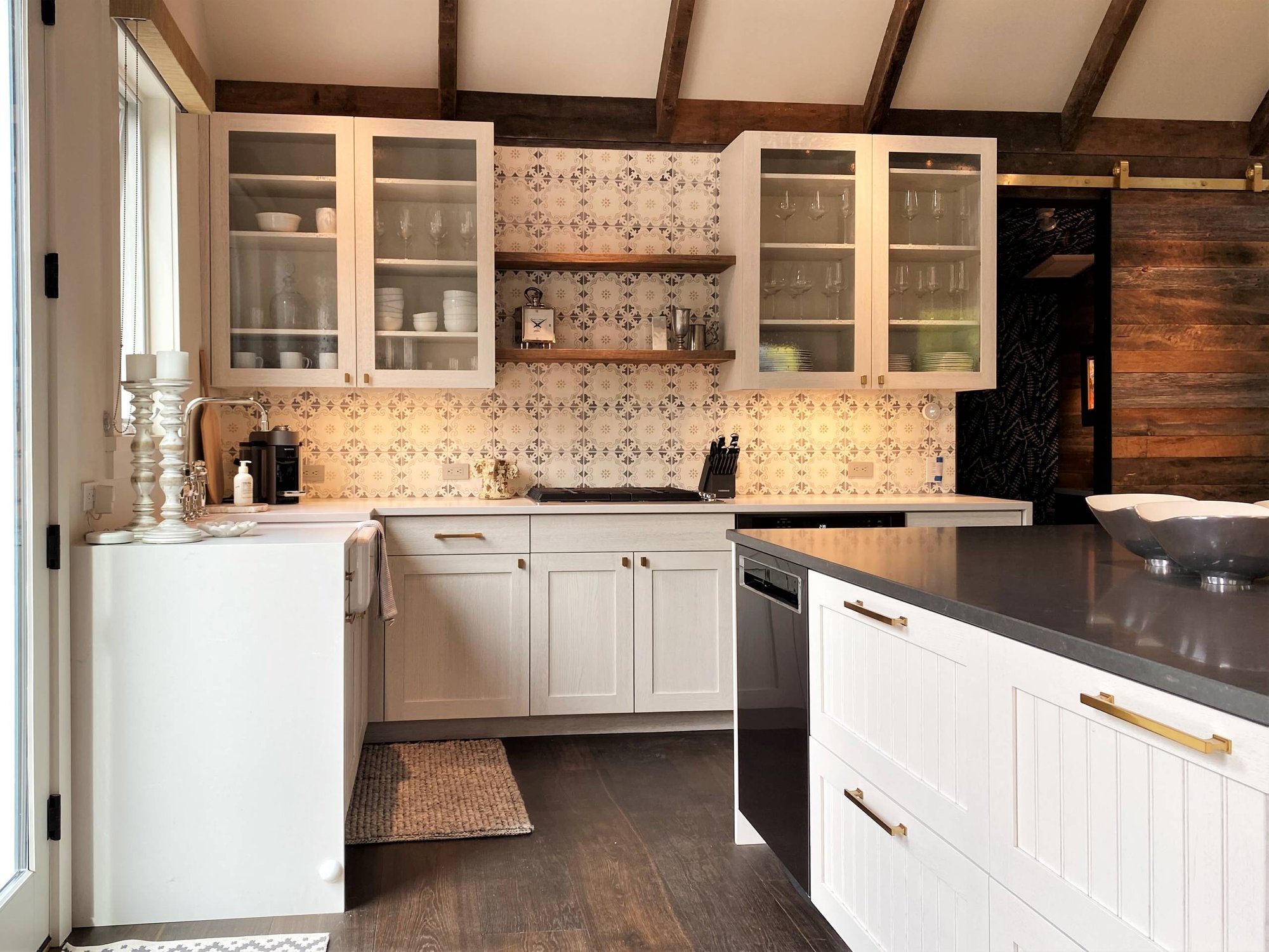 Mid-sized contemporary l-shaped dark wood floor, brown floor and vaulted ceiling open concept kitchen with a farmhouse sink, recessed-panel cabinets, white cabinets, white backsplash, paneled appliances and an island, by Jensen Design in Telluride, CO