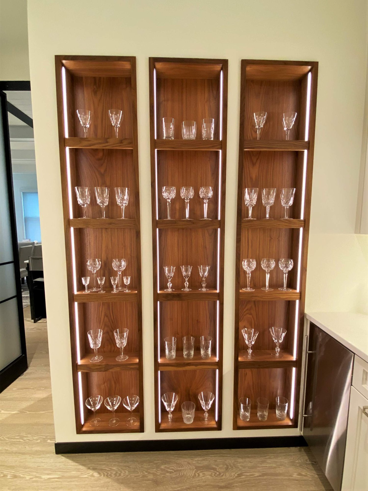 Mid-sized trendy u-shaped light wood floor kitchen pantry with a farmhouse sink, recessed-panel cabinets, white cabinets, white backsplash, stainless steel appliances and white countertops, by Jensen Design in Telluride, CO