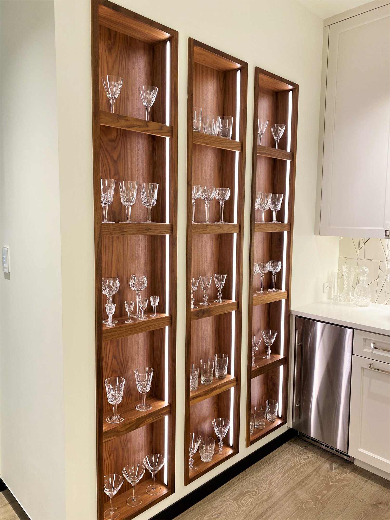 Mid-sized trendy u-shaped light wood floor kitchen pantry with a farmhouse sink, recessed-panel cabinets, white cabinets, white backsplash, stainless steel appliances and white countertops, by Jensen Design in Telluride, CO