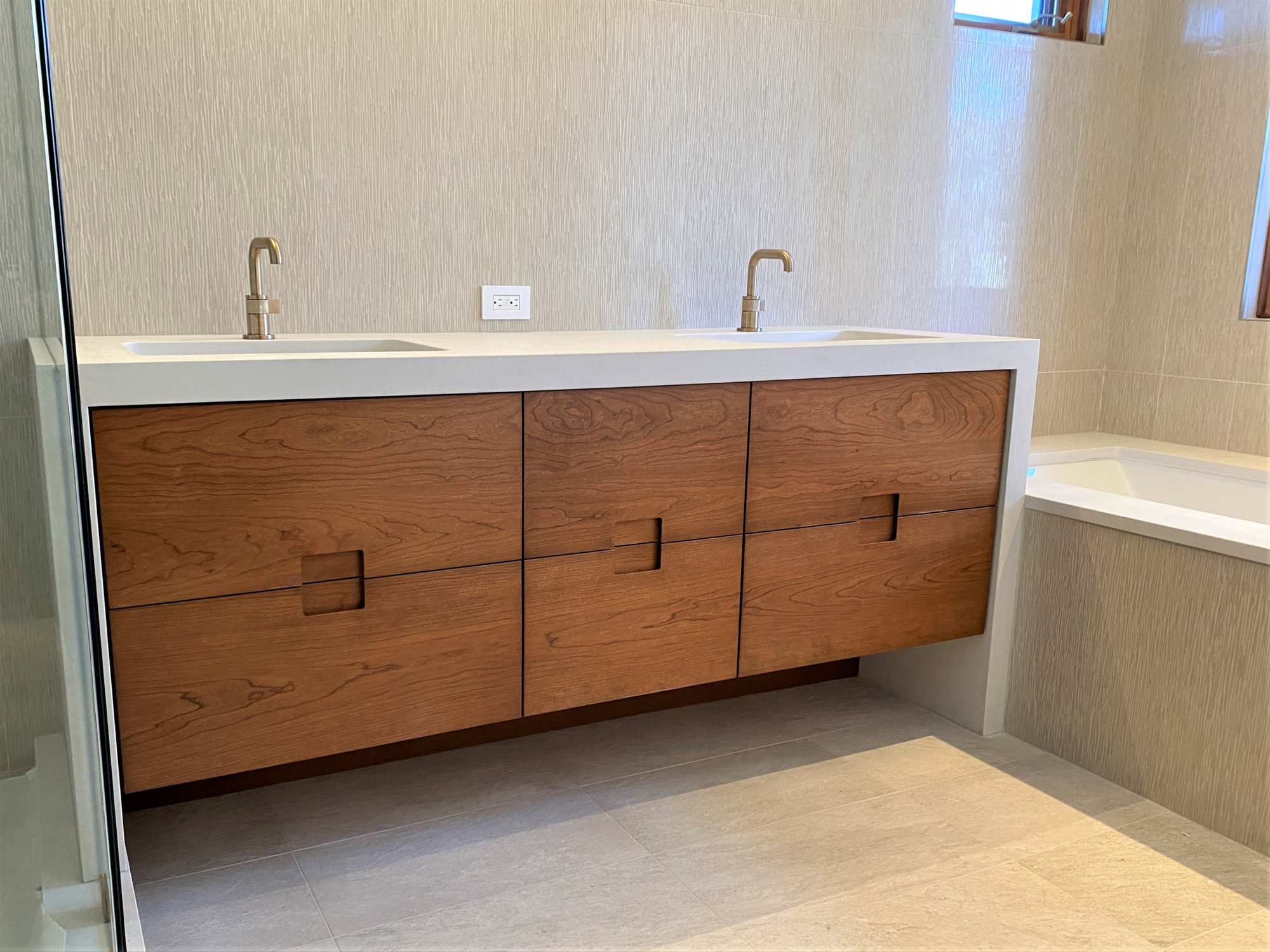 Mid-sized 1950s master white tile white floor and double-sink bathroom with flat-panel cabinets, medium tone wood cabinets, an undermount tub, white countertops and a floating vanity, by Jensen Design in Telluride, CO