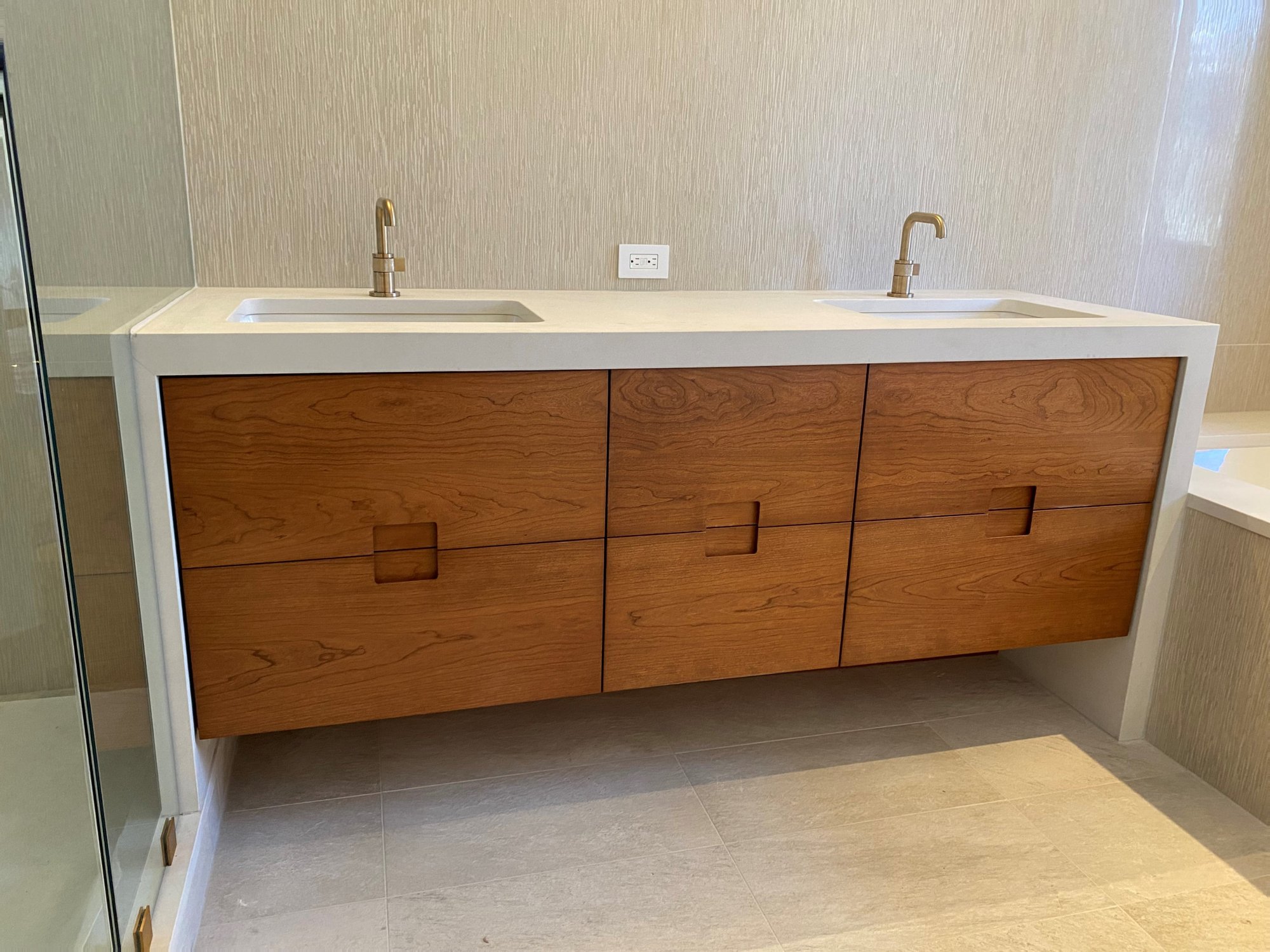 Mid-sized 1960s master white tile white floor and double-sink bathroom with flat-panel cabinets, medium tone wood cabinets, an undermount tub, white countertops and a floating vanity, by Jensen Design in Telluride, CO