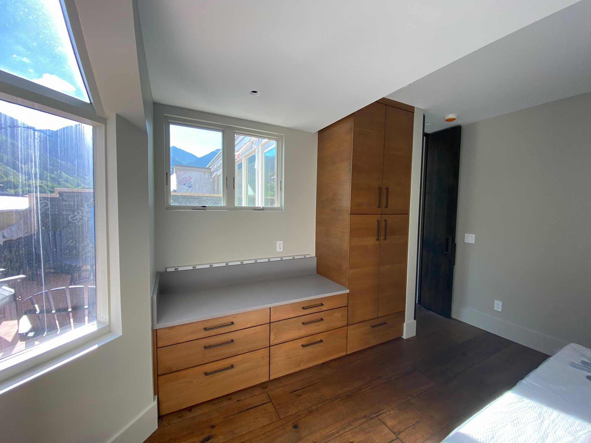 Mid-sized 1950s guest medium tone wood floor and brown floor bedroom with beige walls, by Jensen Design in Telluride, CO