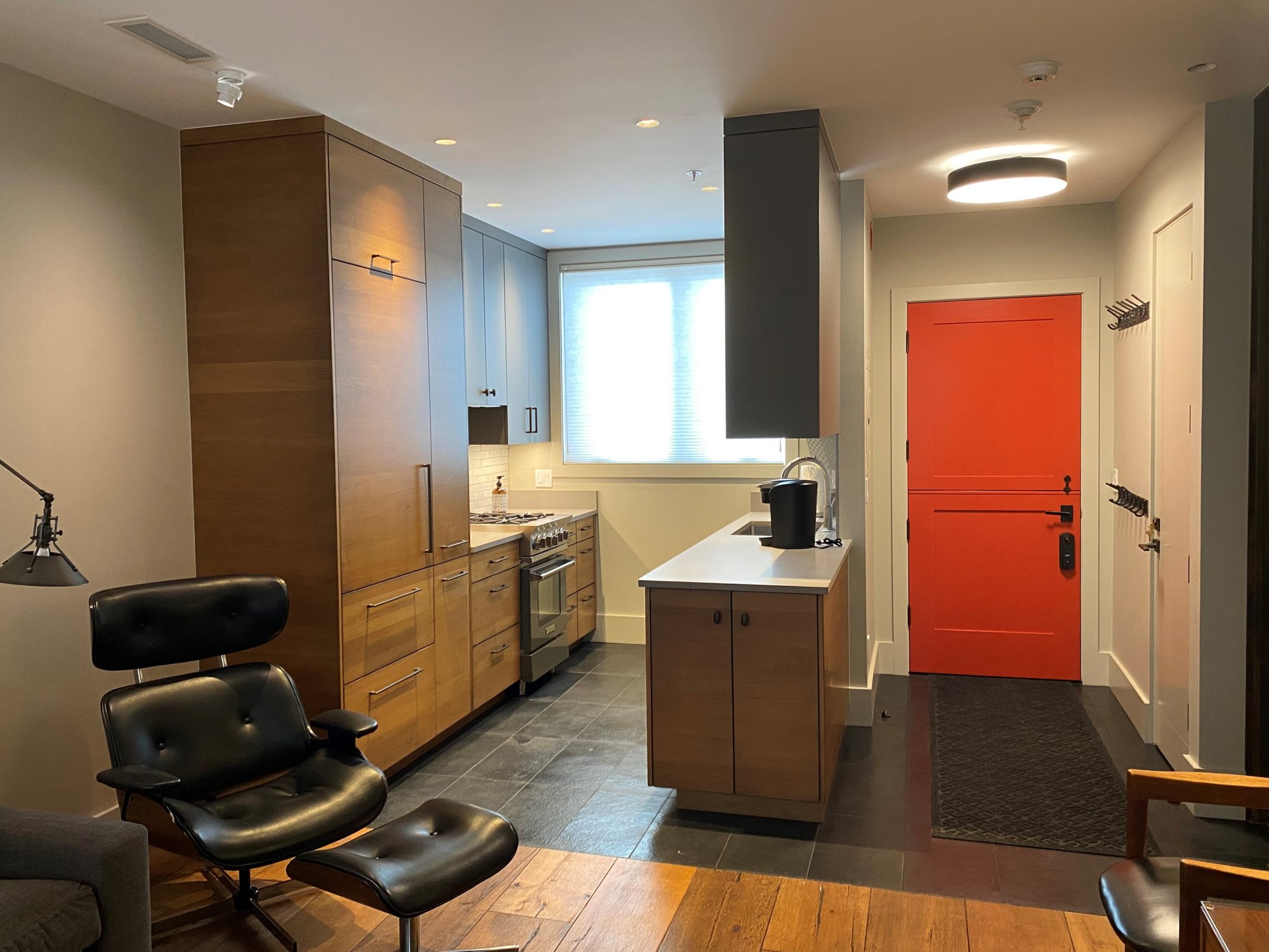 Small 1960s u-shaped open concept kitchen with an undermount sink, flat-panel cabinets, medium tone wood cabinets, concrete countertops, white backsplash, stainless steel appliances and white countertops, by Jensen Design in Telluride, CO