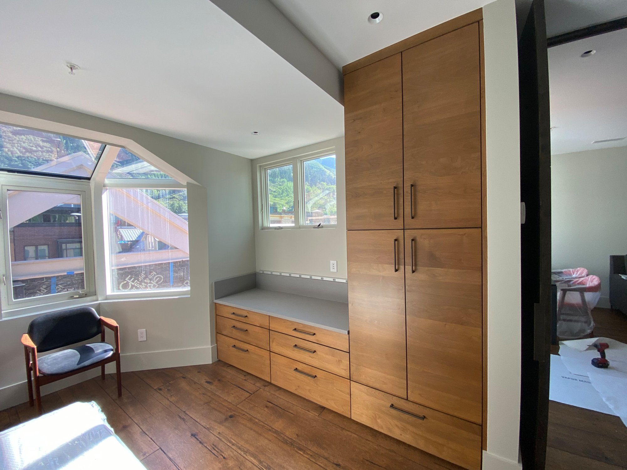 Mid-sized 1950s guest medium tone wood floor and brown floor bedroom with beige walls, by Jensen Design in Telluride, CO
