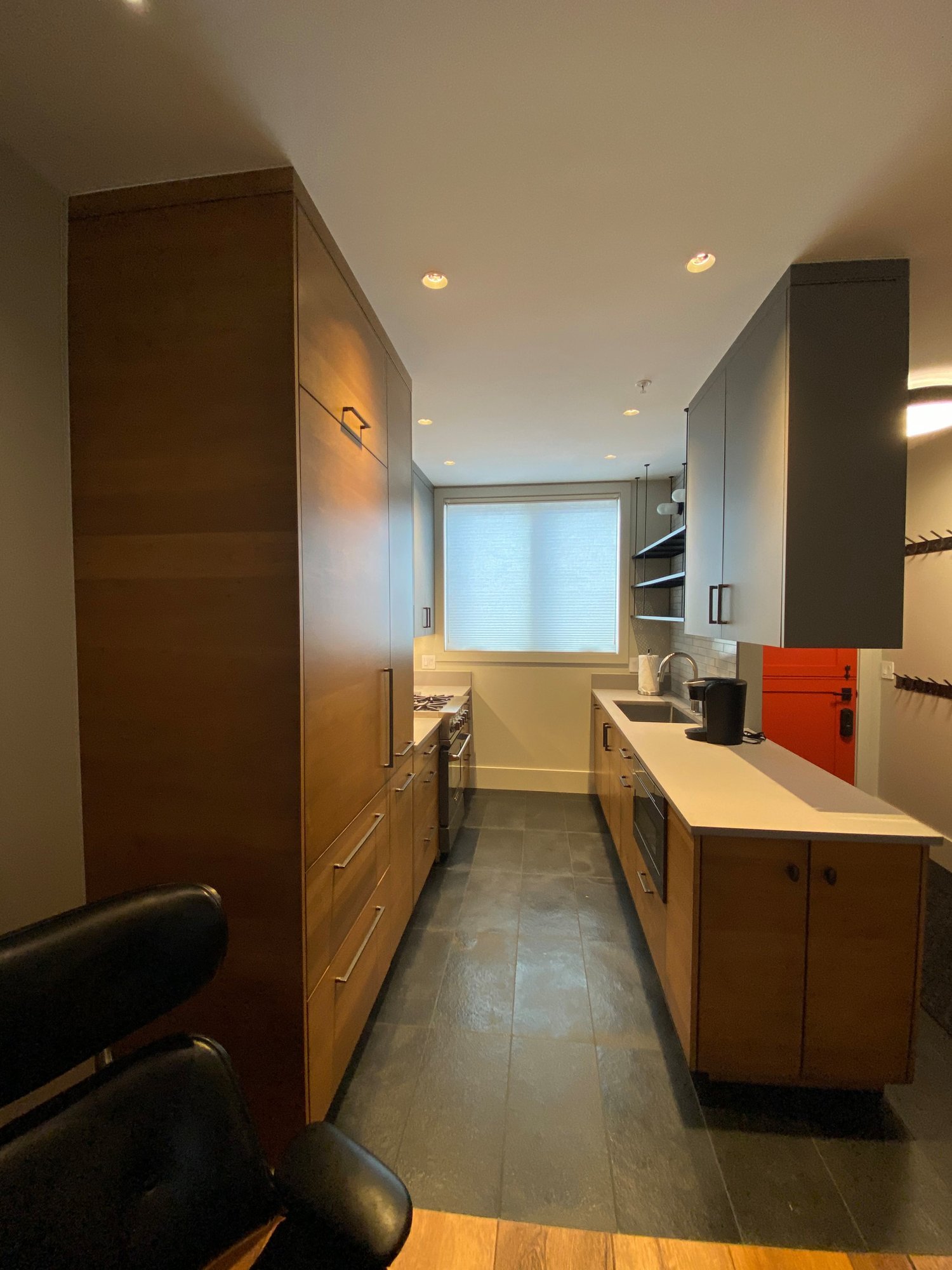 Small 1960s u-shaped open concept kitchen with flat-panel cabinets, medium tone wood cabinets, concrete countertops, white backsplash, stainless steel appliances and white countertops, by Jensen Design in Telluride, CO